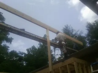 Carpenter setting a ridge beam over a new addition frame — Ice Dam Removal by Roofing Brothers in Hawk Run