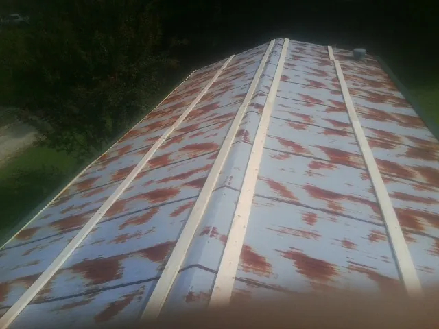 Rusted metal roof panels with new wood purlins before replacement — Storm Damage Roof Repair in Hawk Run by Roofing Brothers