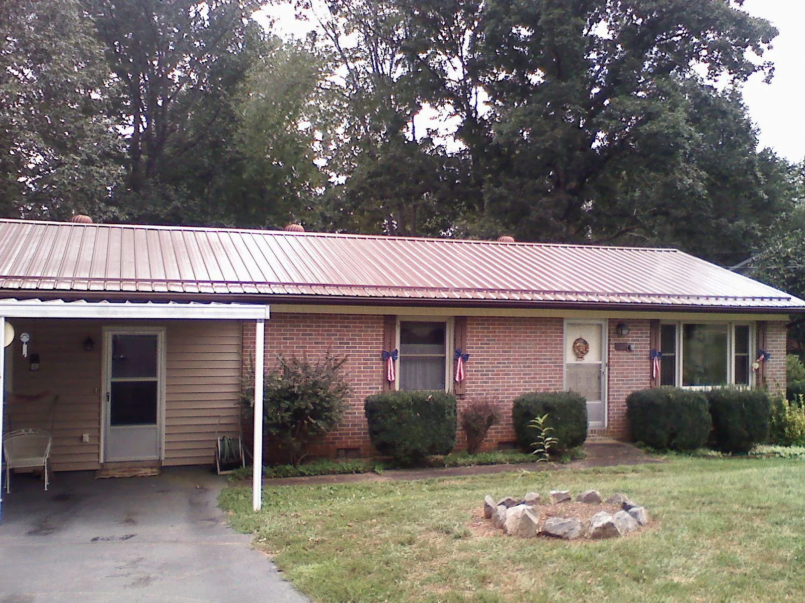 Bronze metal roof and carport on a brick ranch home — Roof Repair work by our crew in Hawk Run